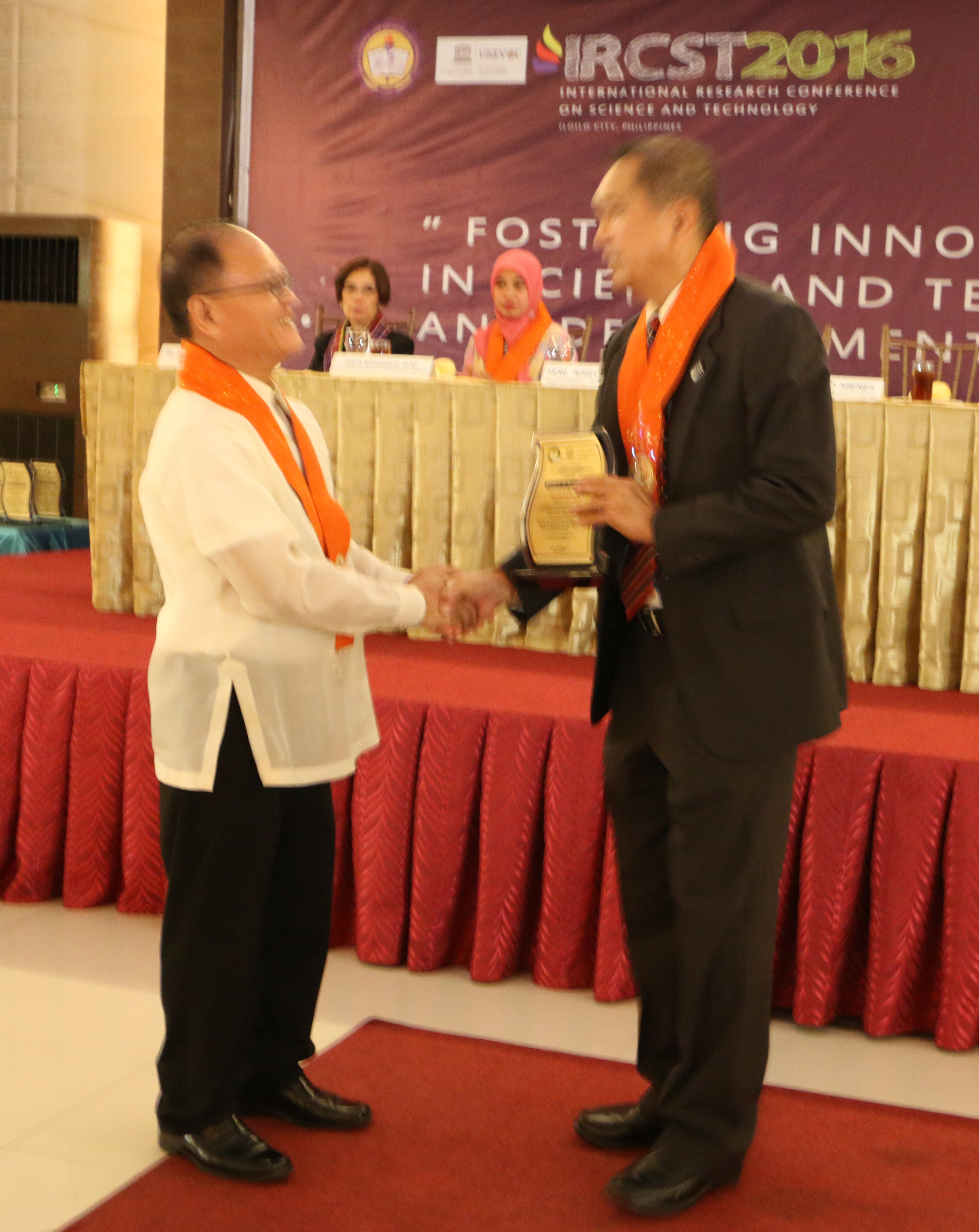 ISAT U President Dr. Raul F. Muyong gives the Plague of Recognition to Dr. Fiorillo B. Abenes of the USAID-STRIDE.